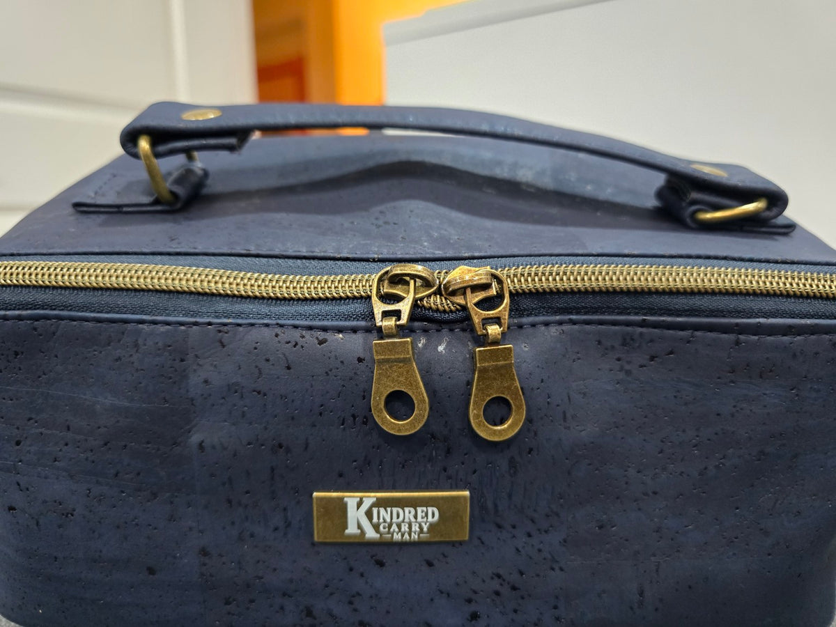 Navy cork Charles Dopp Kit close-up showing antique brass double zipper and Kindred Carry Man label