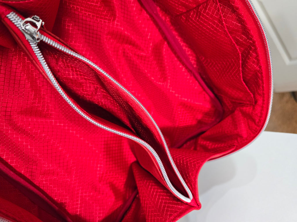 Red Charles Dopp Kit interior showing zippered center divider and slip pockets