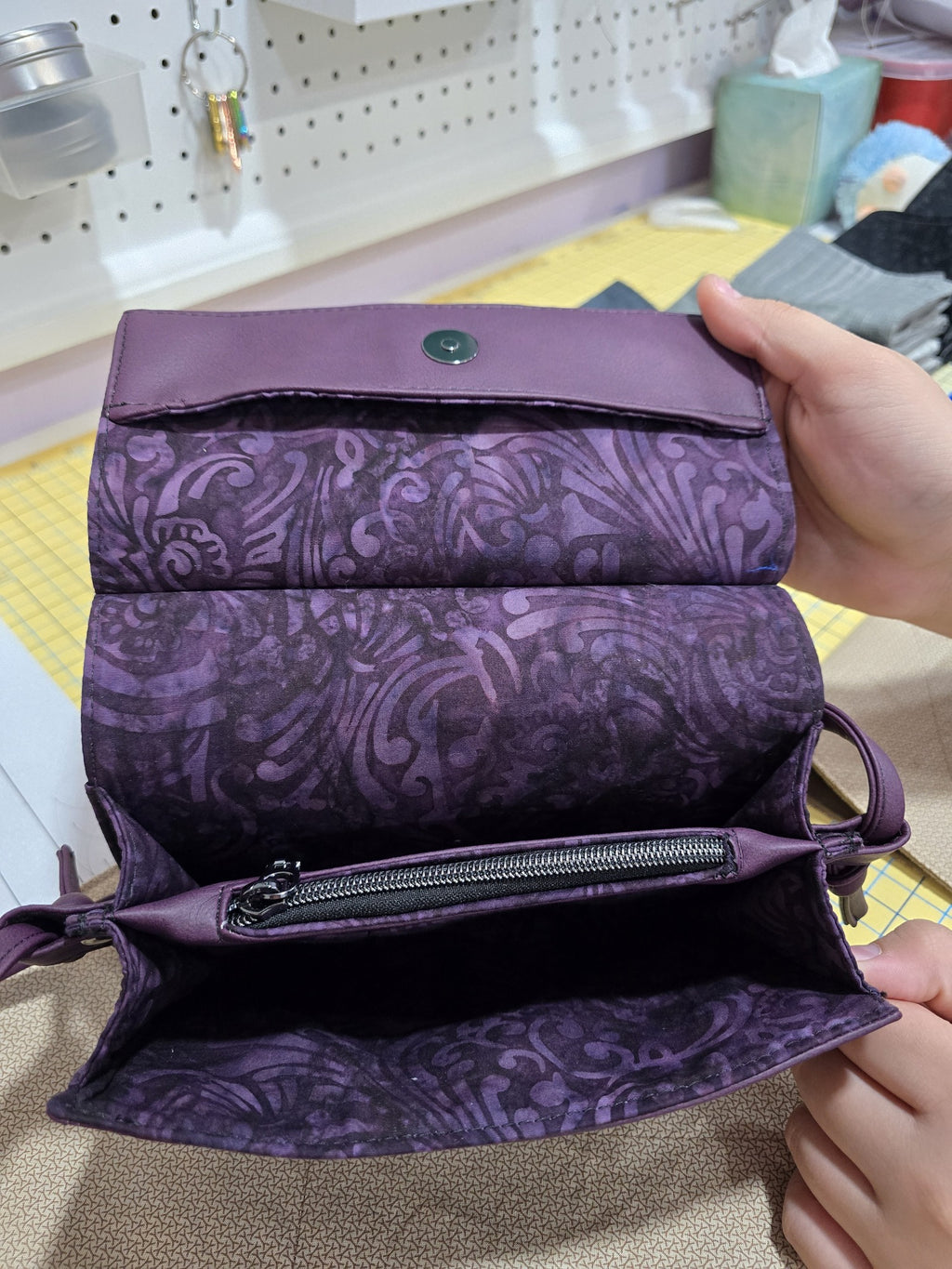 Open interior of purple Janine clutch showing coordinating cotton lining and center zip pocket
