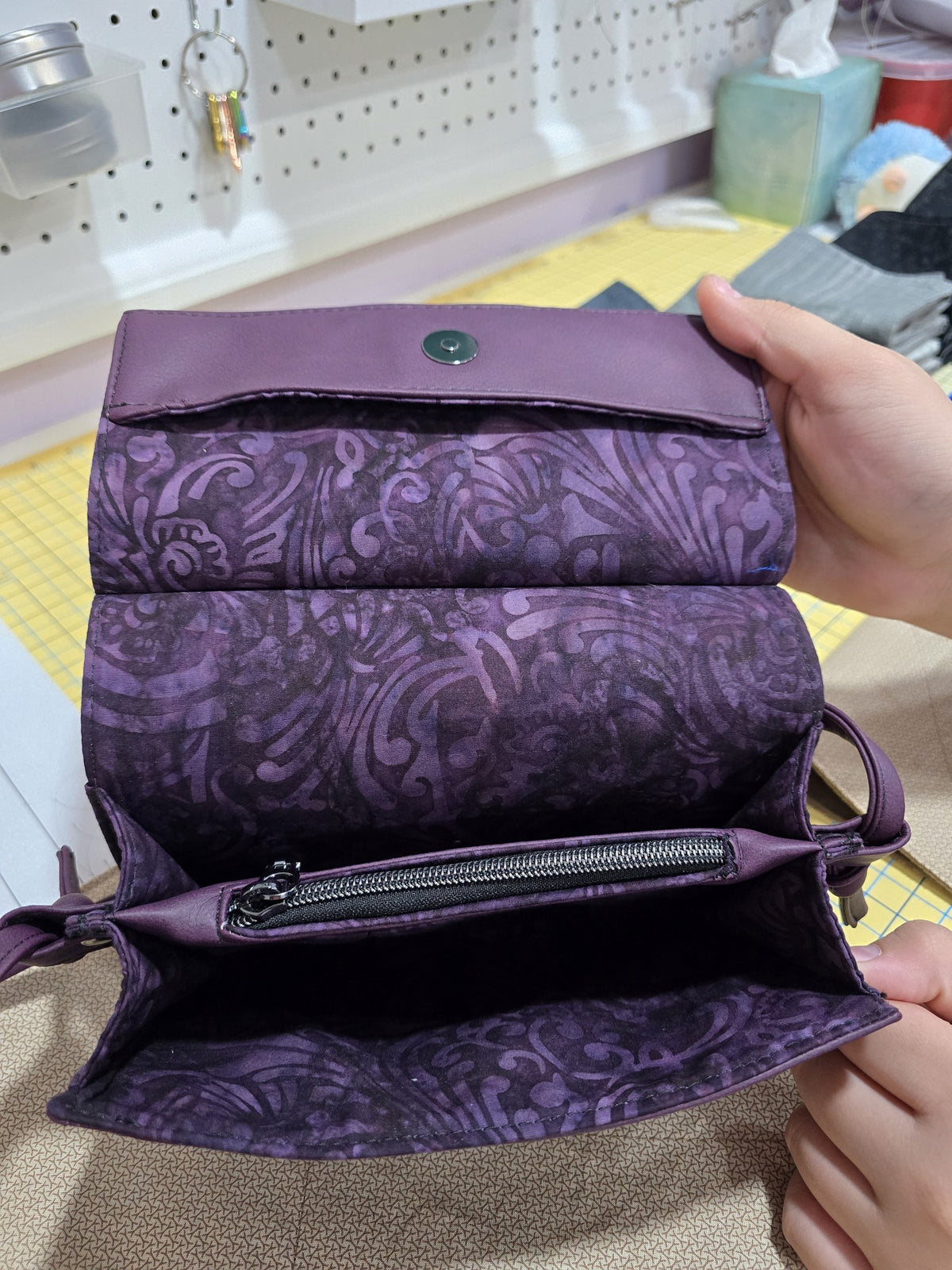Open interior of purple Janine clutch showing coordinating cotton lining and center zip pocket