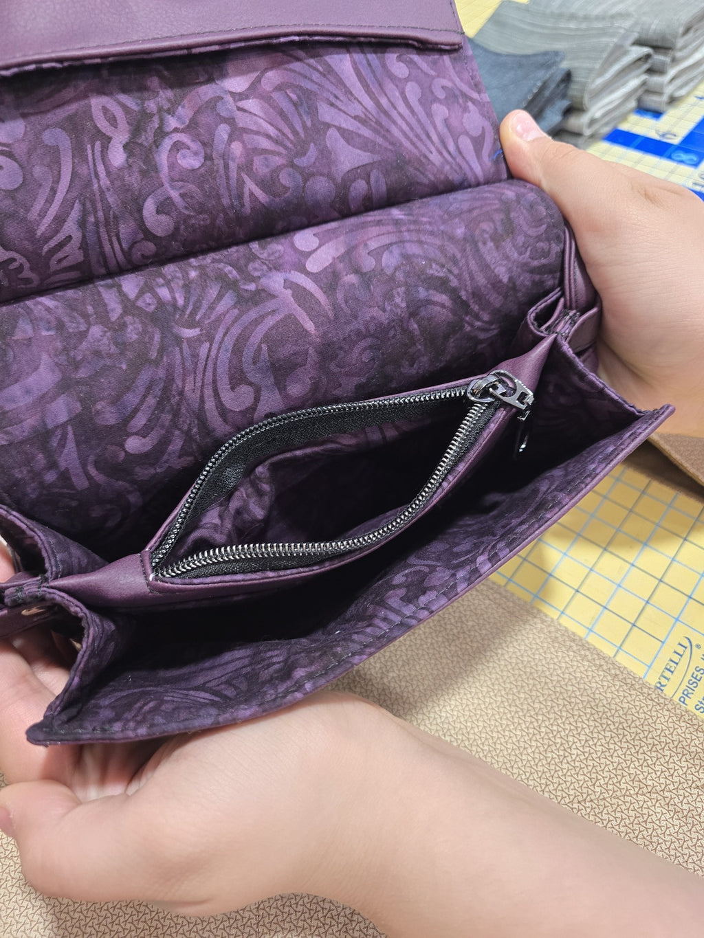 Interior zip pocket and purple cotton lining inside the Janine clutch
