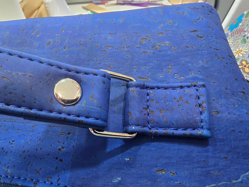 Detail of blue cork handle, stitching and polished silver-tone handle hardware on Charles Dopp Kit