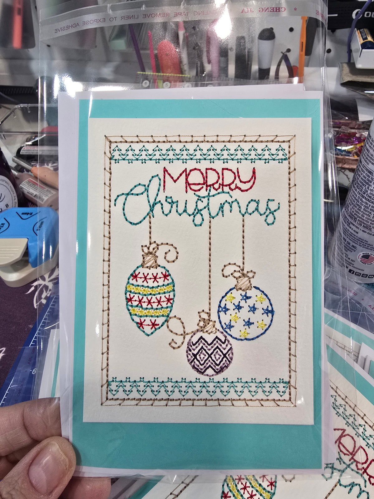 Kindred Carry embroidered Christmas greeting card with three hanging ornaments and Merry Christmas